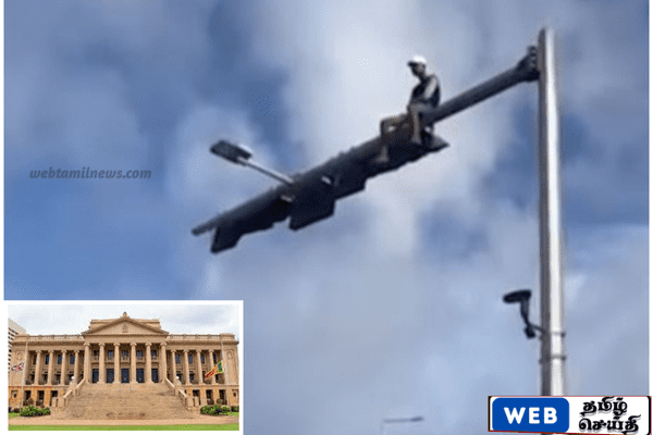 ஜனாதிபதி செயலகம் முன் போக்குவரத்து சமிக்ஞை கம்பத்தில் ஏறிய நபர்
